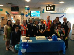 The WestJet team gathers around the cake and celebrates the arrival of the very first Encore aircraft to YVR. 