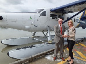 Michael O’Brien, Vancouver Airport Authority corporate secretary and VP of strategic planning, legal services and environment, presents Meredith Moll, Harbour Air Group vice president sales and marketing, with the 2015 Clear Skies Award.