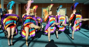 A chorus line of female dancers in can-can garb greet Air North passengers at YVR check-in.